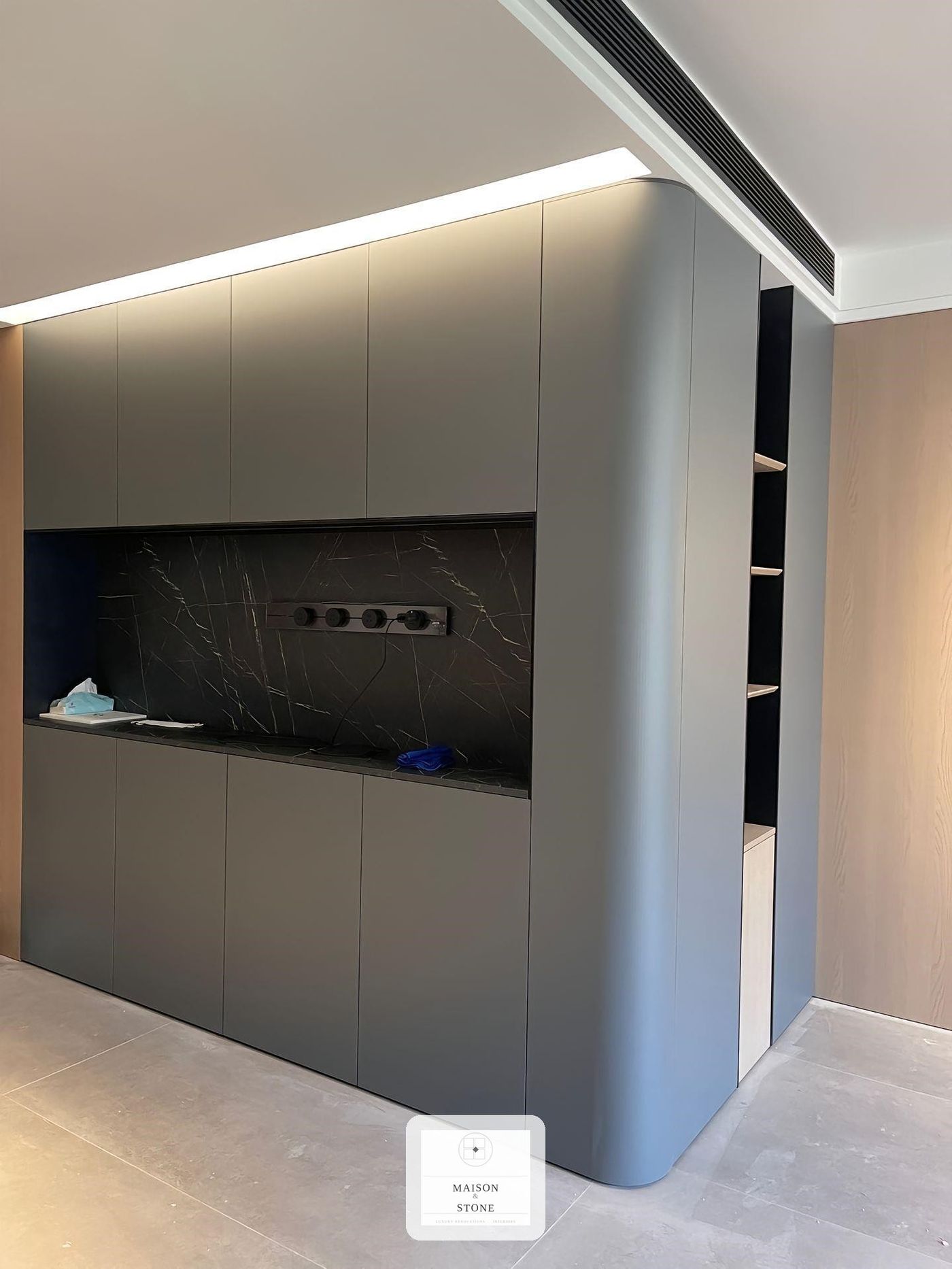 Built-in media wall with curved cabinetry and marble panel, custom interior renovation by Maison & Stone